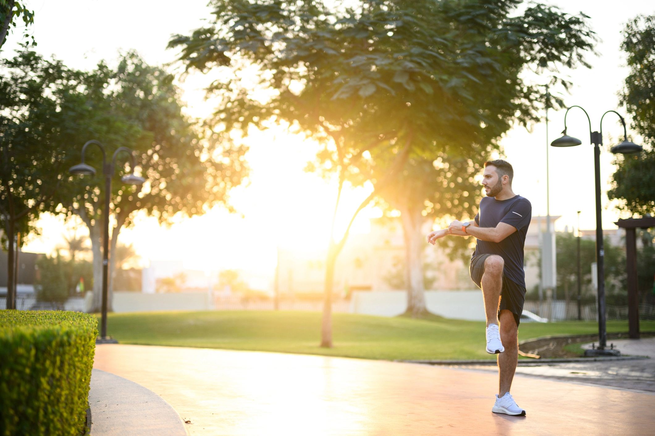 Person stretching outdoors in a peaceful park at sunrise